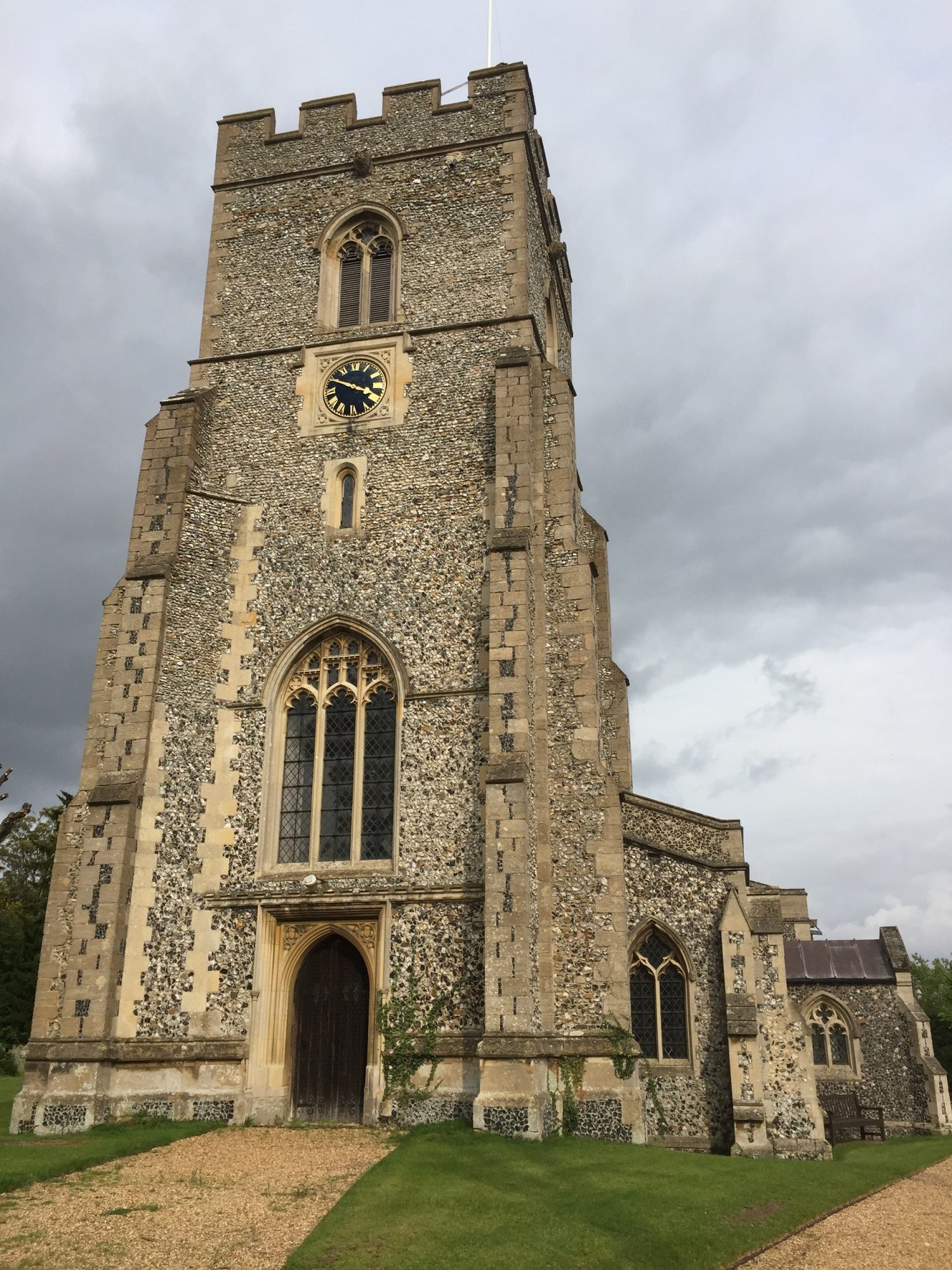 A square flint tower with a clock