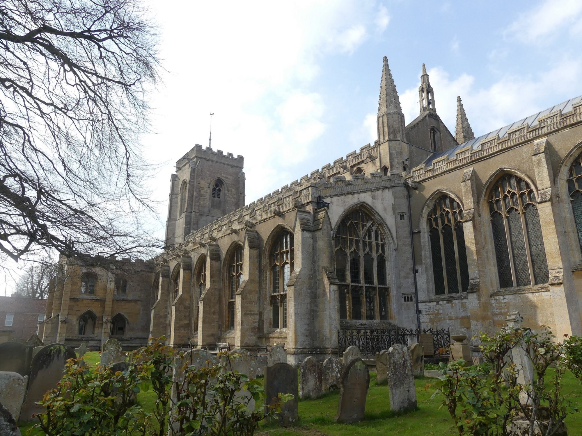 Exterior of a church, the walls are mostly filled with huge, perpendicular windows and held up with large buttresses between each window