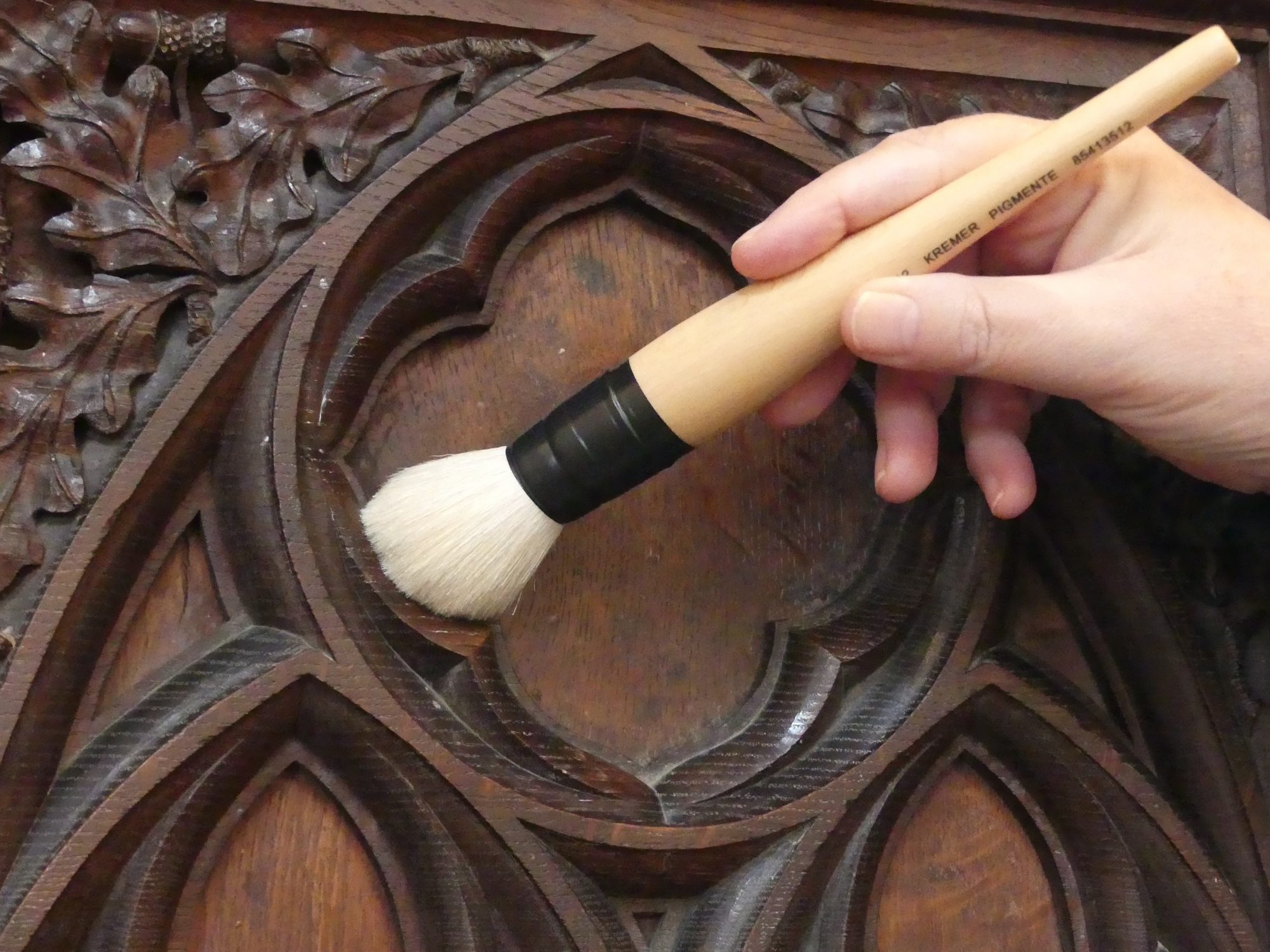 A soft brush cleaning carved woodwork