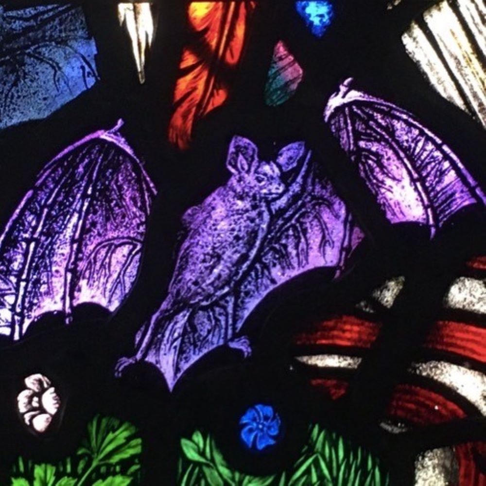 A purple stained glass bat from a window at West Grinstead church