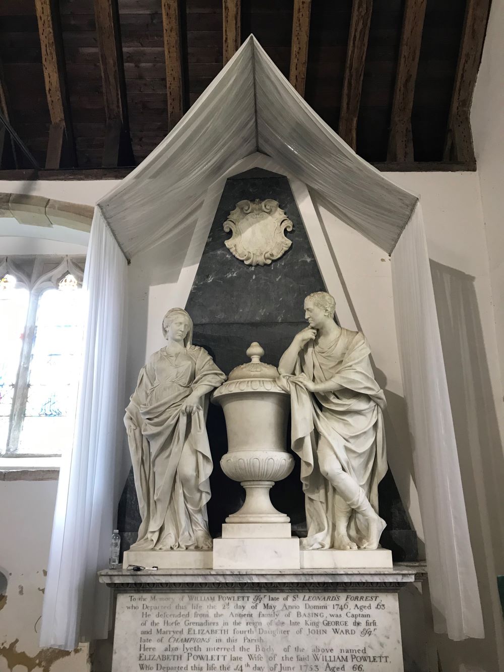 A tent-shaped fabric canopy over a monument at West Grinstead church