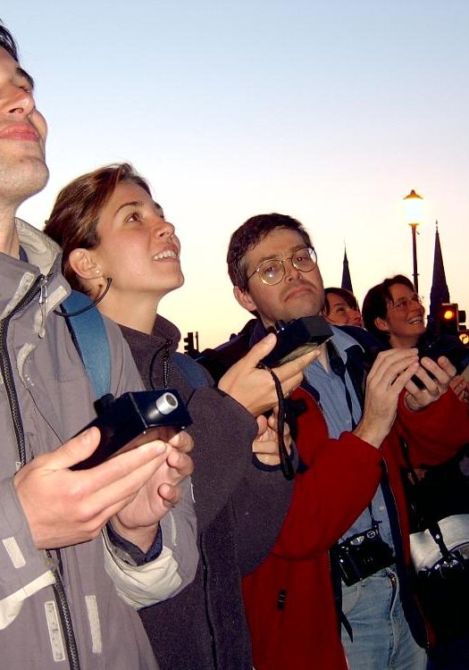 A group of young people on a city street using bat detectors