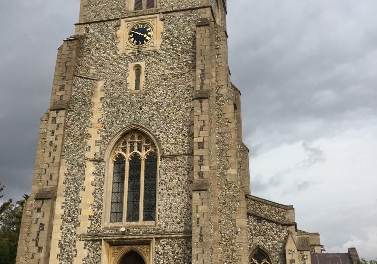 A square flint tower with a clock