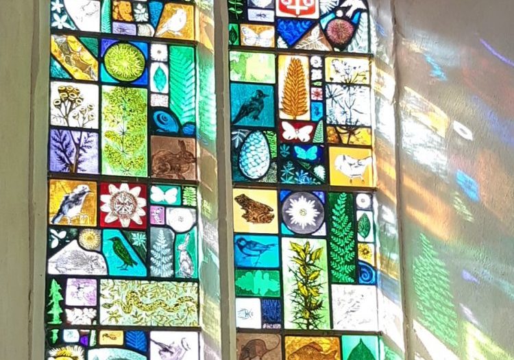 A two light window filled with stained glass of local wildlife