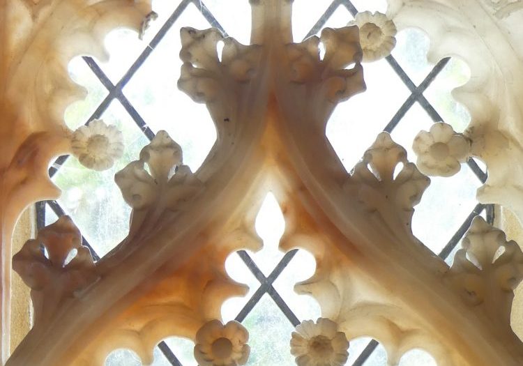 Sunlight through a leaded church window with stone traceries