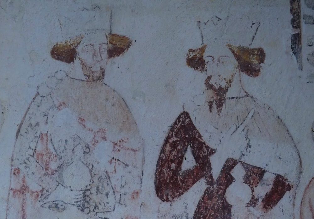A medieval painting showing the outline of two crowned men in cloaks carrying gifts