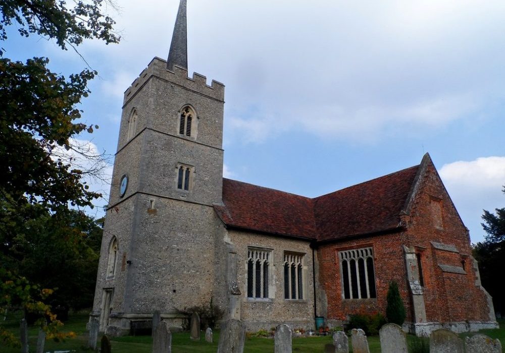 Stone tower and nave with brick South Chapel and gravestones in foreground