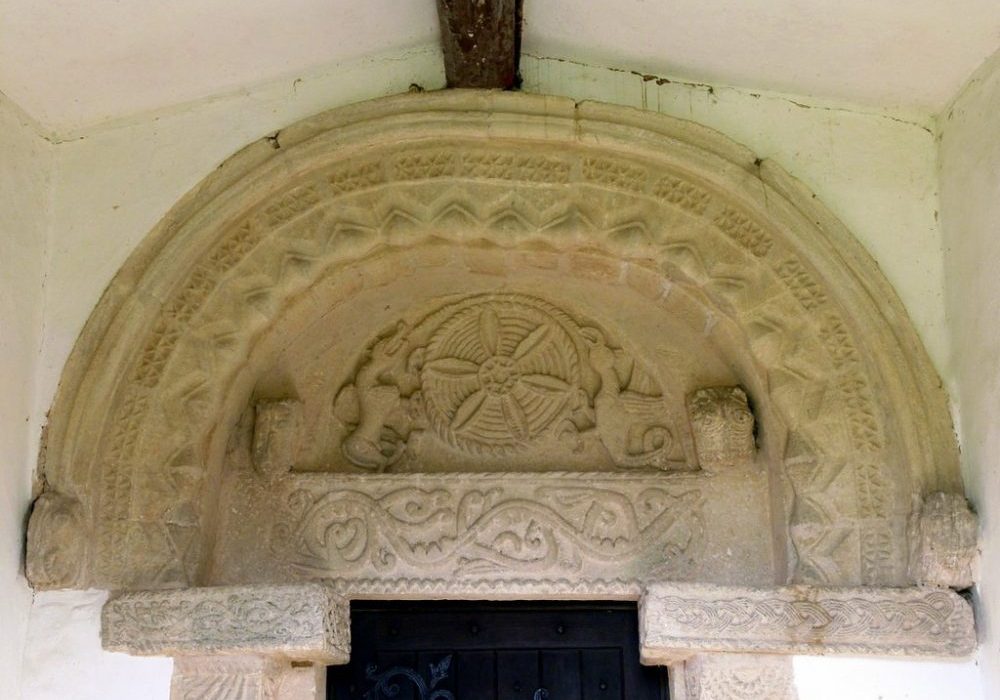 Carved stone above church door depicting mythical beasts and foliage