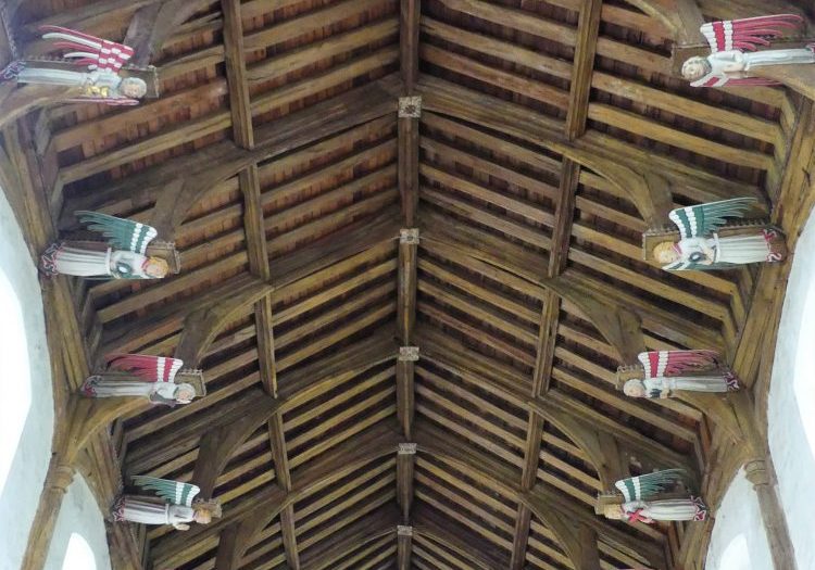 A church roof with multicoloured painted angels on the hammer beams