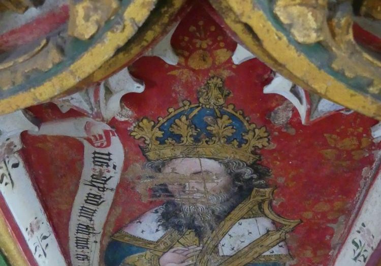 A painted rood screen showing King David in a gold crown and carrying a harp