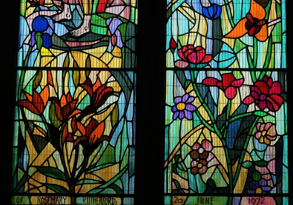 Stained glass dated 1972 showing graphic, abstract flowers and plants