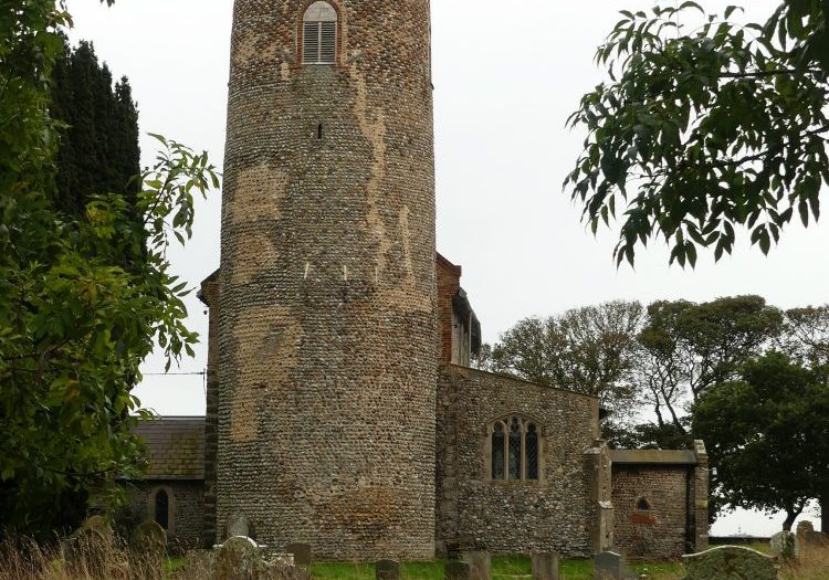 The round tower of a church, made from regular small bricks