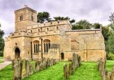 Image shows the exterior of Stevington Church and its graveyard