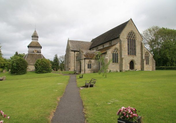 Large church surrounded by grass and with a separate octagonal belfy next to it